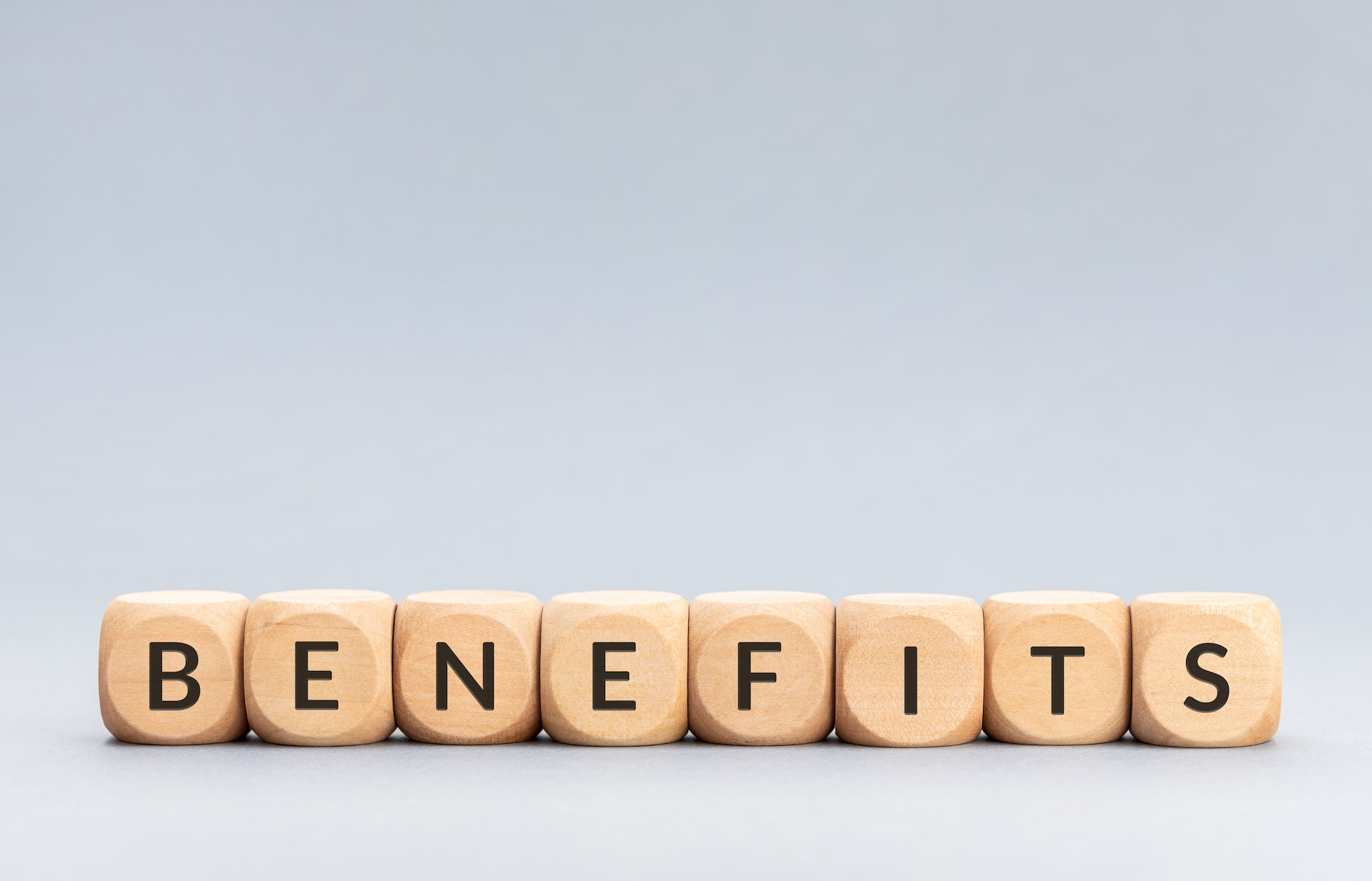 Benefits word on wooden blocks on gray background