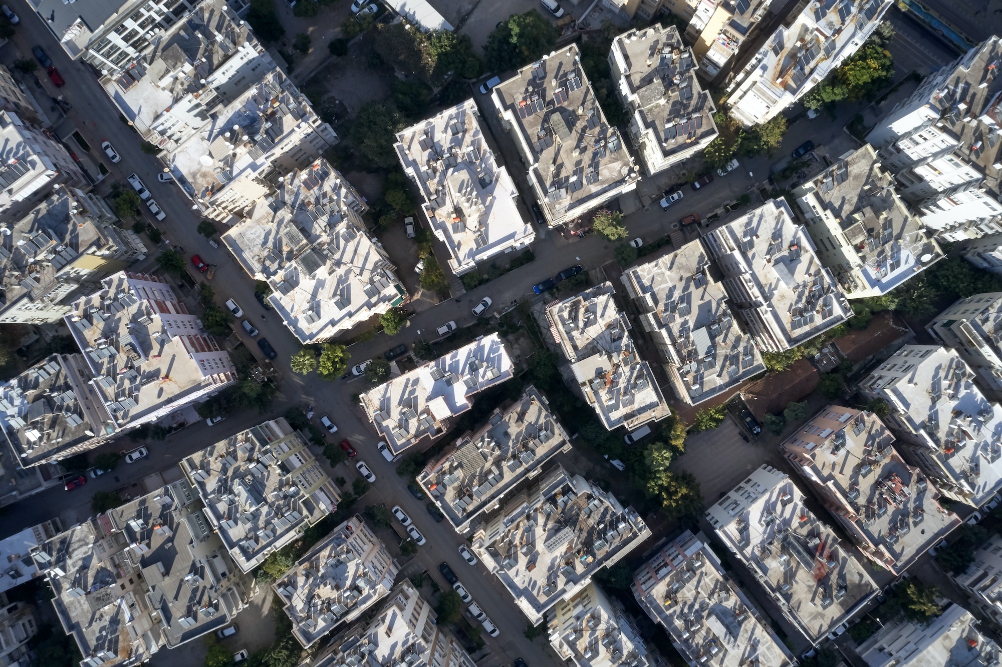 Aerial view of rooftops of urban buildings with solar panels.